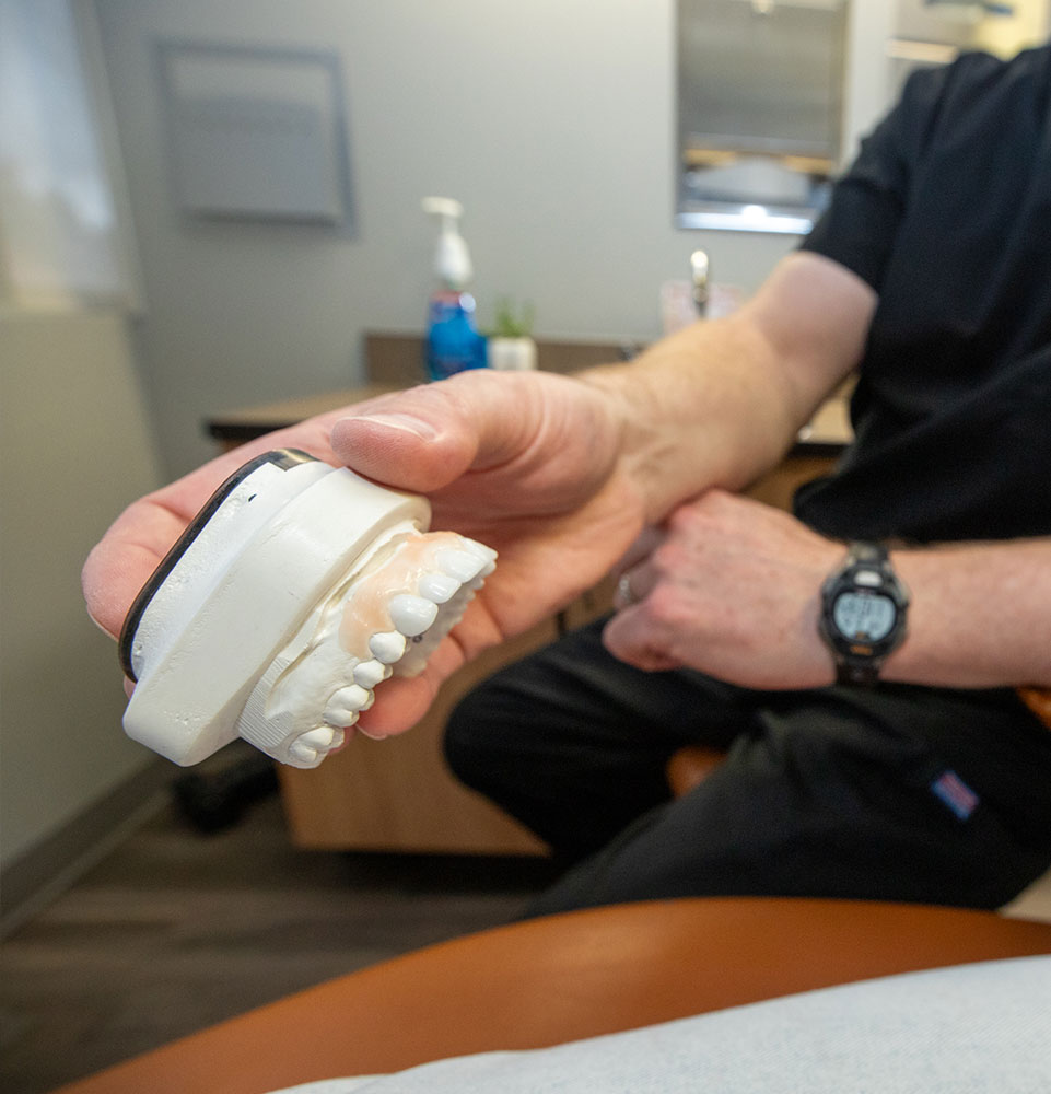 doctor looking at dental procedure model within the dental practice