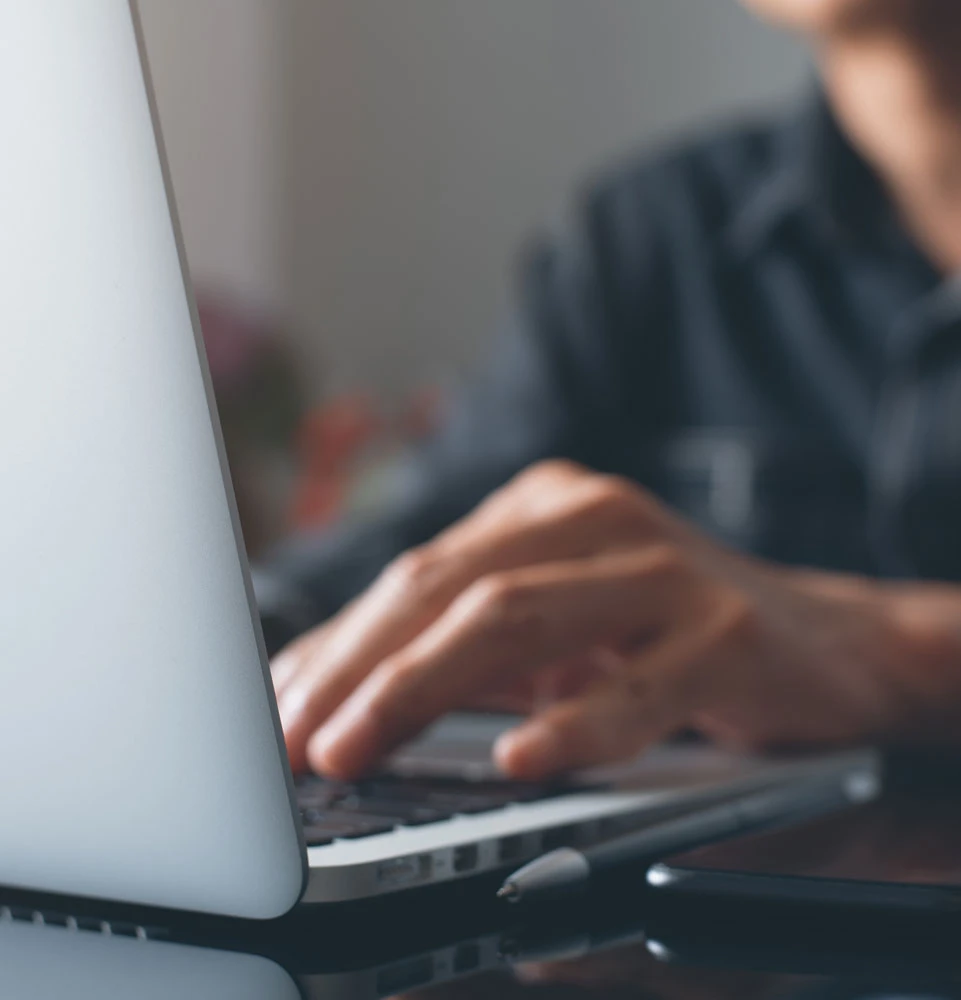 Guy typing into a laptop to contact Standley Shores Dental Group